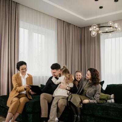 A joyful family consults with a real estate agent in their modern living room.