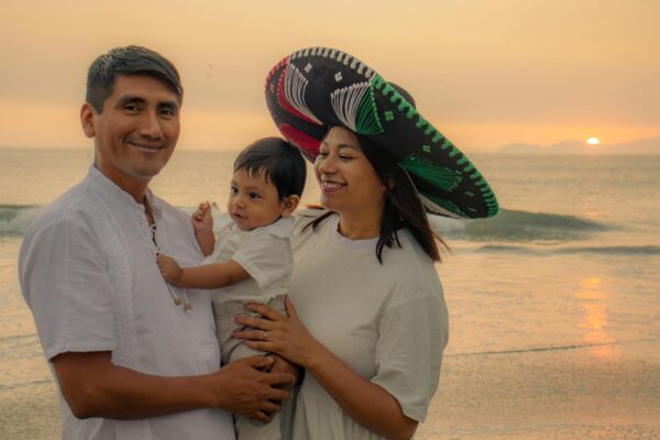 A joyful family moment captured on a beach at sunset, embodying love and happiness.